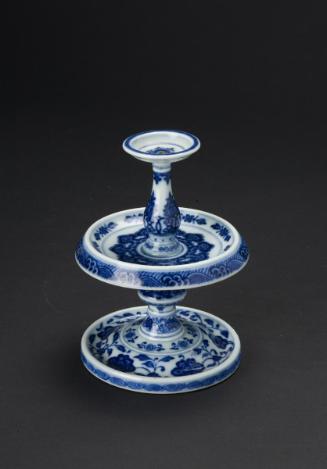 Candlestick with design of floral scrolls over ocean waves