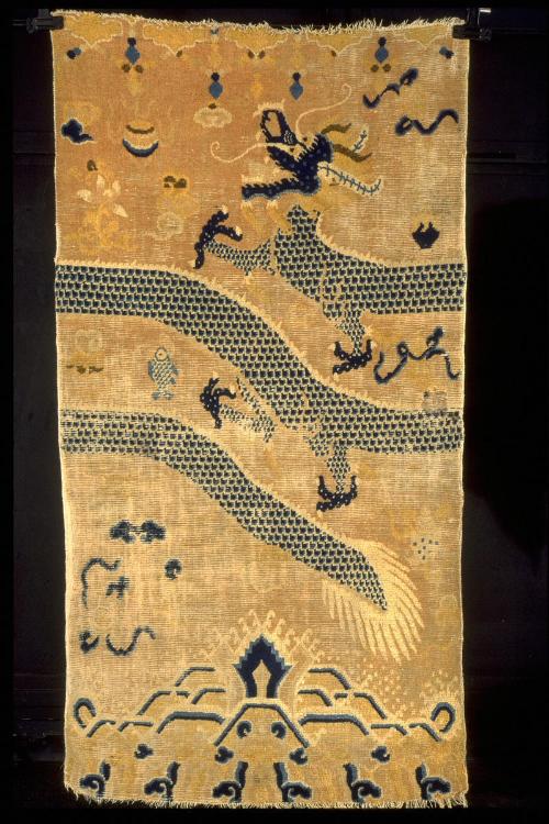 Rug with a design of a dragon amid treasures