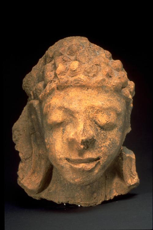 Head of a figure wearing large earrings