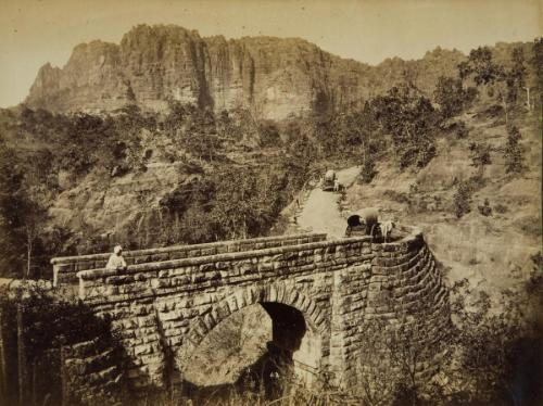 Stone bridge and road through a mountainous landscape