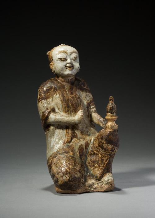 Kneeling figure holding a fan